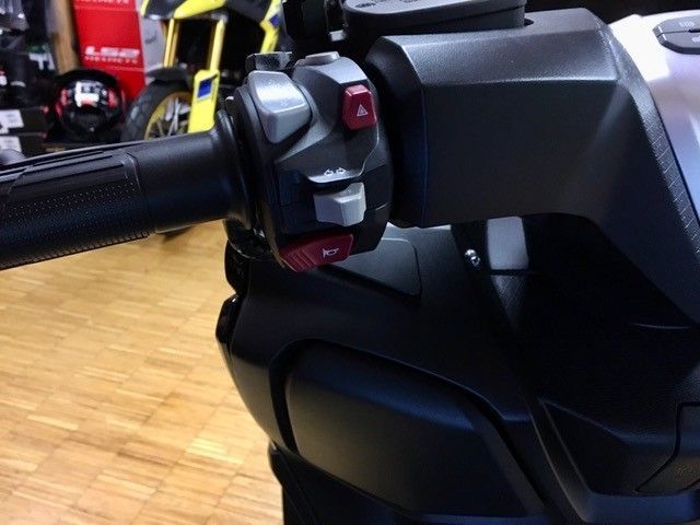 Eine Nahaufnahme eines Motorradlenkers mit einem roten Knopf darauf