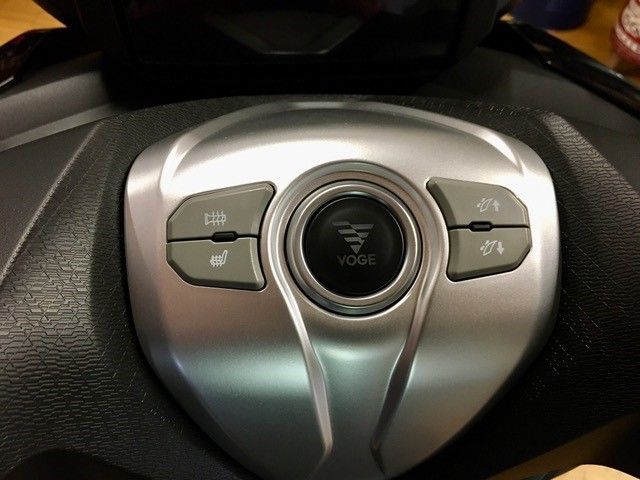 Eine Nahaufnahme eines Lenkrads mit einer Taste mit der Aufschrift „Modus“