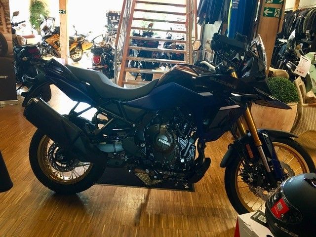 Ein schwarzes Motorrad ist auf einem Holzboden in einem Geschäft geparkt