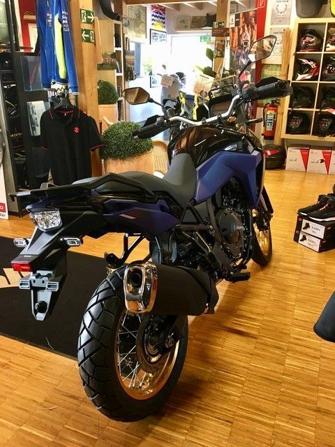 Ein blaues Motorrad steht in einem Ausstellungsraum