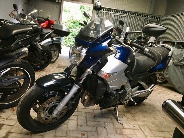 Ein blau-silbernes Motorrad steht in einer Garage