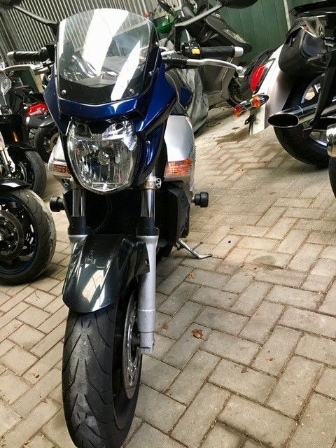 Eine Reihe von Motorrädern sind auf einer gepflasterten Auffahrt geparkt