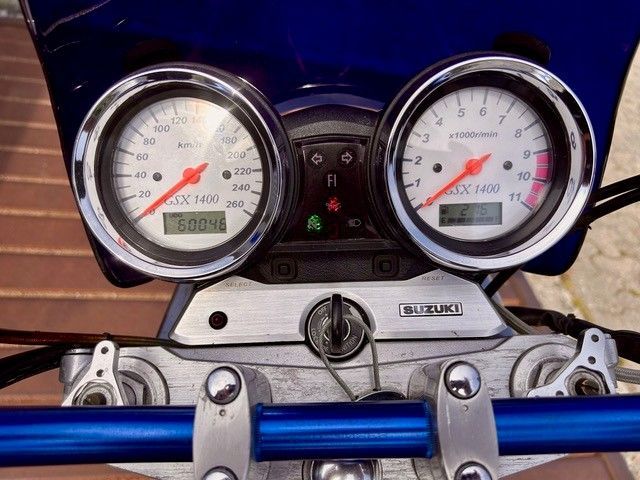 Motorrad-Armaturenbrett mit zwei verchromten Instrumenten, blauem Lenker und Suzuki-Emblem
