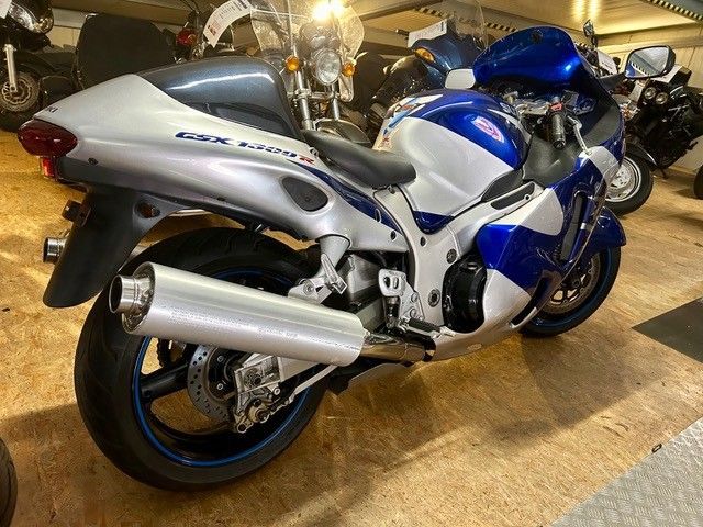 Ein blau-silbernes Sportmotorrad steht in einer Halle zur Schau.