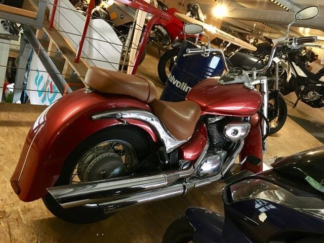 Ein rotes Motorrad steht mit anderen Motorrädern in einer Garage