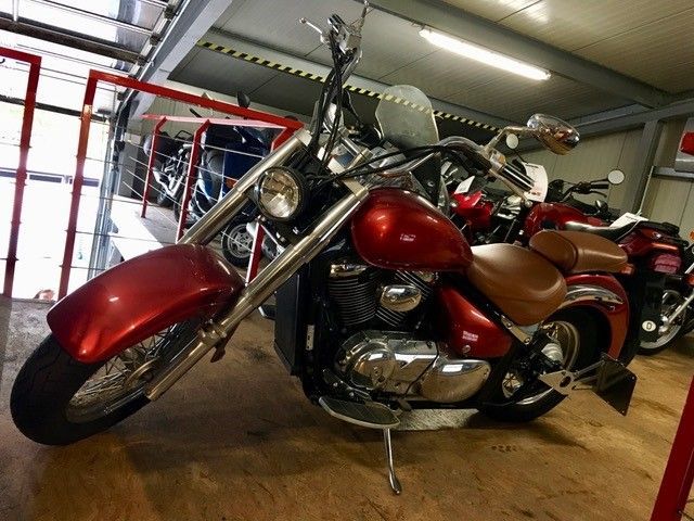 Ein rotes Motorrad steht mit anderen Motorrädern in einer Garage