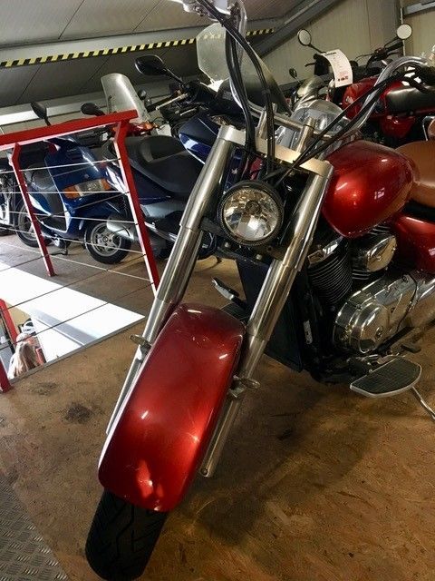 Ein rotes Motorrad steht mit anderen Motorrädern in einer Garage