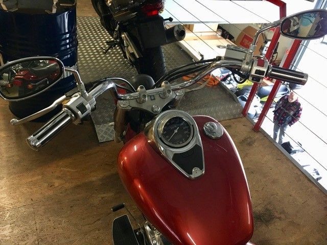 Ein rotes Motorrad steht in einer Garage neben einem schwarzen Motorrad