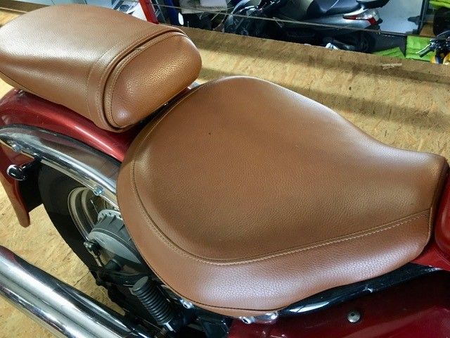 Ein brauner Ledersitz auf einem roten Motorrad