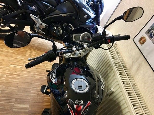 Ein Triumph-Motorrad steht neben einem Kühler