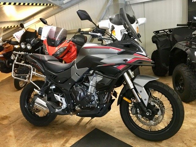 In einem Ausstellungsraum ist ein Motorrad neben anderen Motorrädern geparkt.