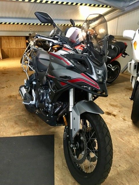 Ein Motorrad ist in einer Garage mit anderen Motorrädern geparkt