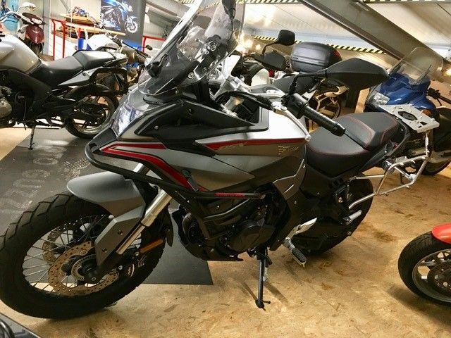 Ein Motorrad ist in einer Garage mit anderen Motorrädern geparkt