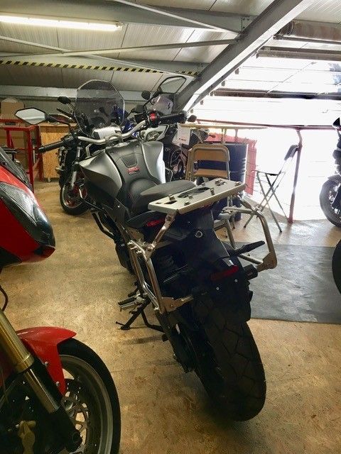 Ein Motorrad ist in einer Garage mit anderen Motorrädern geparkt