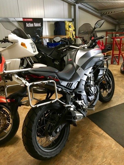 Ein Motorrad steht neben einem anderen Motorrad in einer Garage