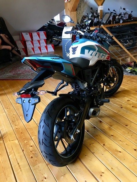 Ein Motorrad ist auf einem Holzboden in einem Raum geparkt