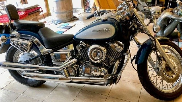 In einer Garage steht ein blau-silbernes Motorrad.