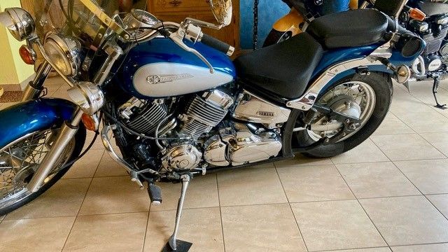 Ein blaues Motorrad steht auf einem gefliesten Boden in einer Garage.