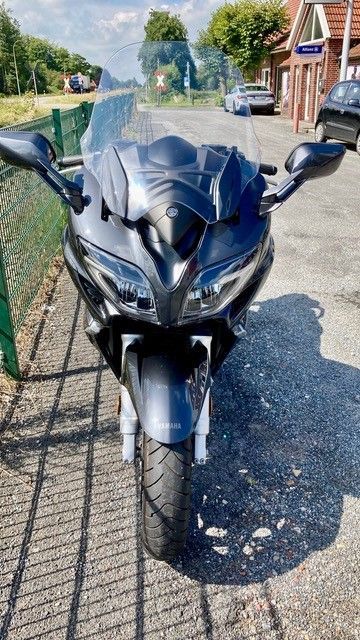 Ein schwarzes Motorrad ist am Straßenrand geparkt.