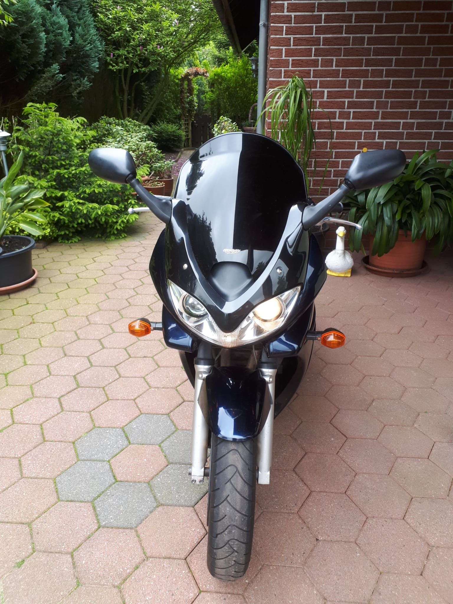 Ein schwarzes Motorrad steht vor einem Backsteingebäude