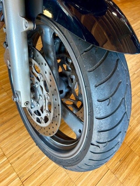 Eine Nahaufnahme eines Motorradrads auf einem Holzboden