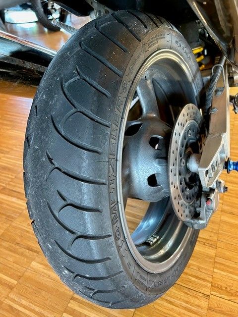 Eine Nahaufnahme eines Motorradreifens auf einem Holzboden