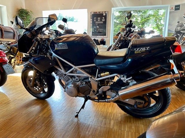 In einem Ausstellungsraum steht ein schwarzes Motorrad.