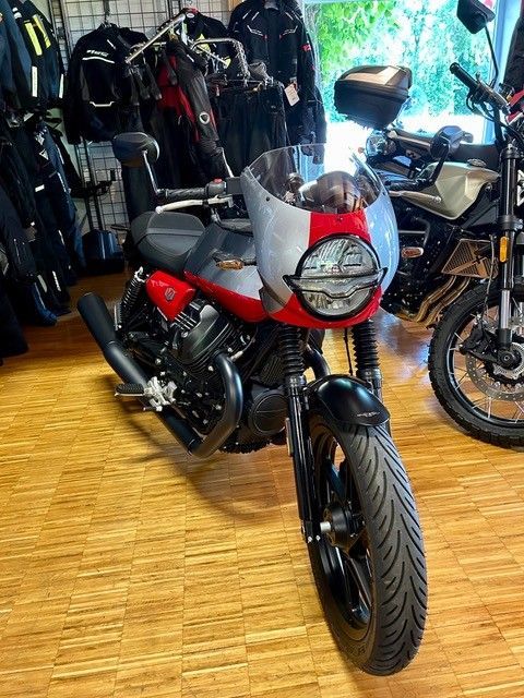 In einem Ausstellungsraum steht ein Motorrad auf einem Holzboden.