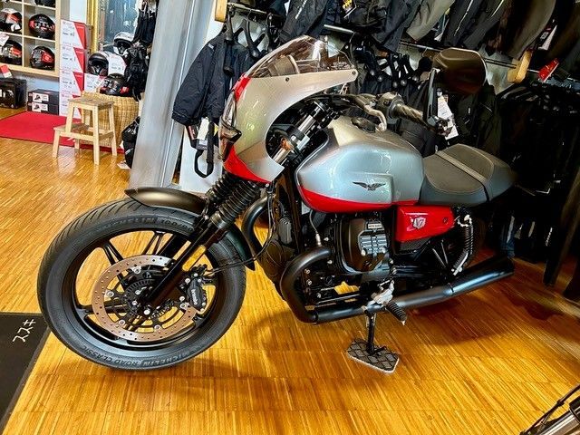 In einem Geschäft ist auf einem Holzboden ein Motorrad geparkt.