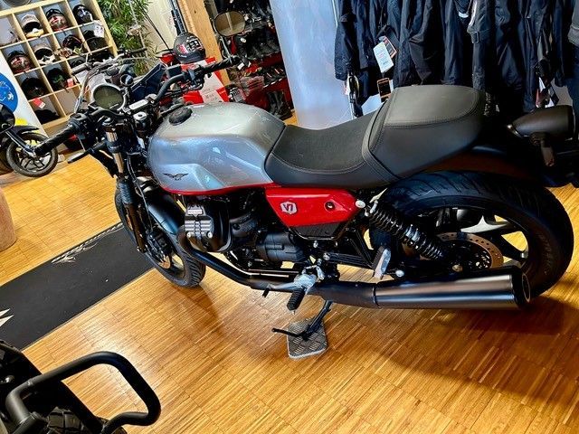 In einem Ausstellungsraum ist ein Motorrad auf einem Holzboden geparkt.