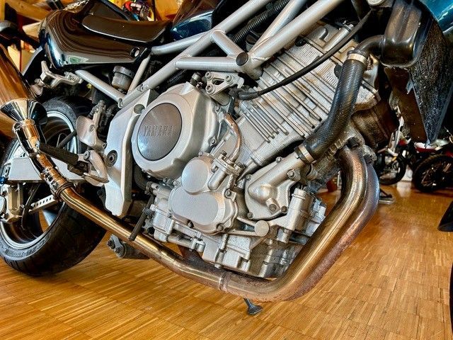 Eine Nahaufnahme eines Motorradmotors auf einem Holzboden