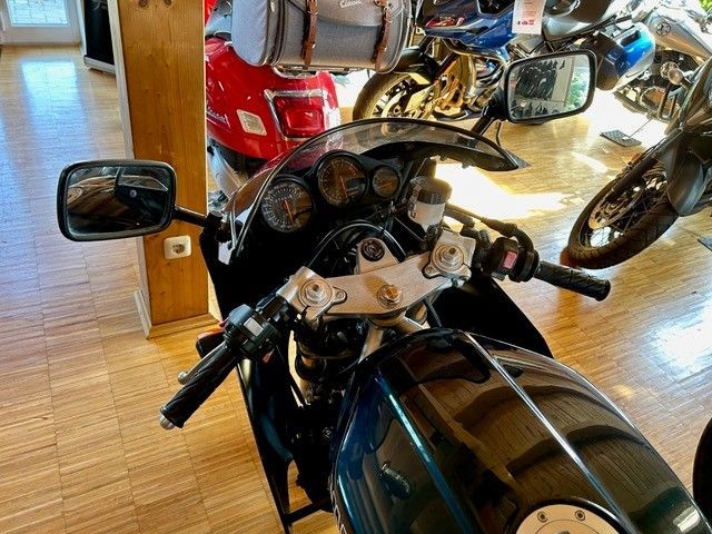 Ein Motorrad ist in einem Raum mit anderen Motorrädern geparkt.