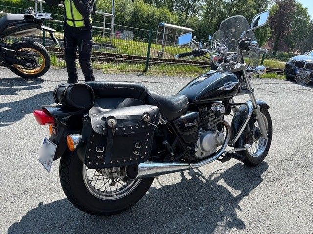 Ein Mann steht neben einem schwarzen Motorrad