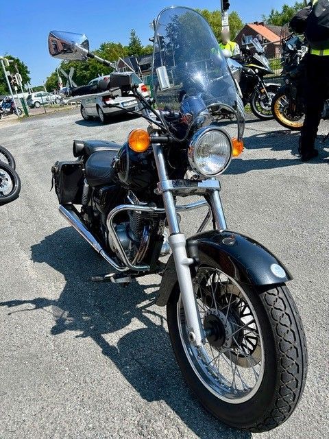 Ein schwarzes Motorrad mit Windschutzscheibe steht auf einem Parkplatz