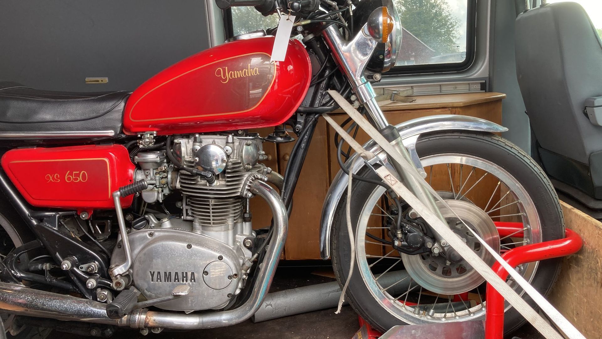 Ein rotes Yamaha-Motorrad steht auf der Ladefläche eines Lieferwagens