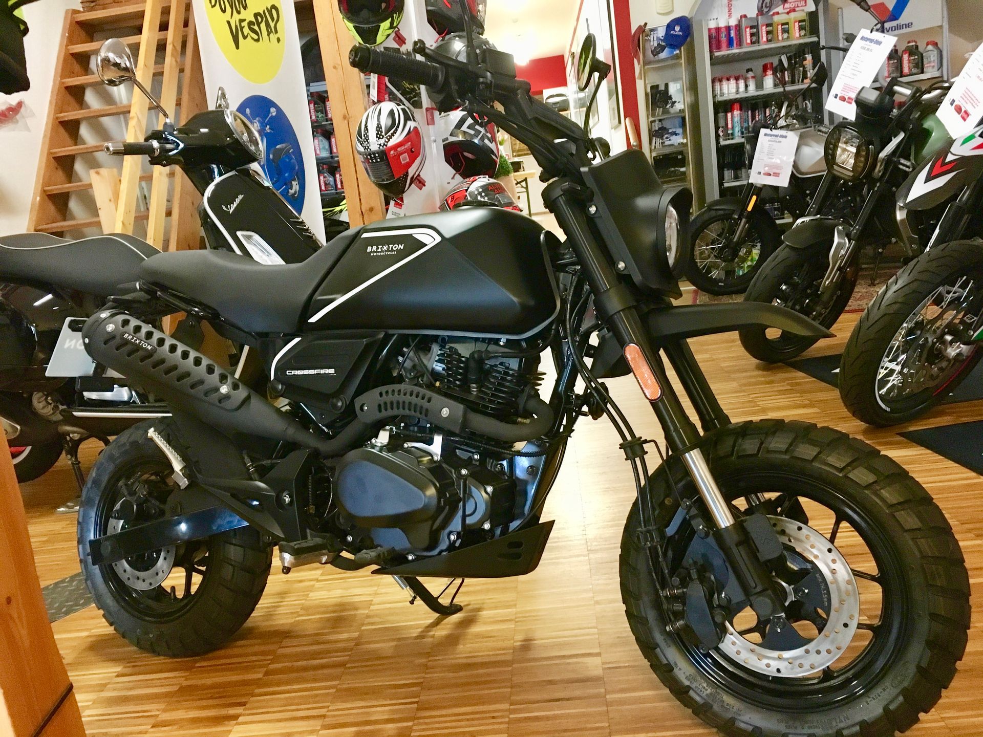 In einem Ausstellungsraum steht ein schwarzes Motorrad.