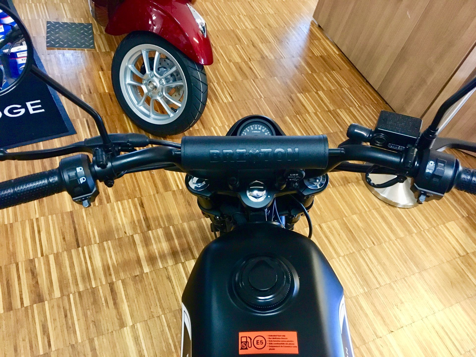 Ein Motorrad ist auf einem Holzboden in einer Garage geparkt.