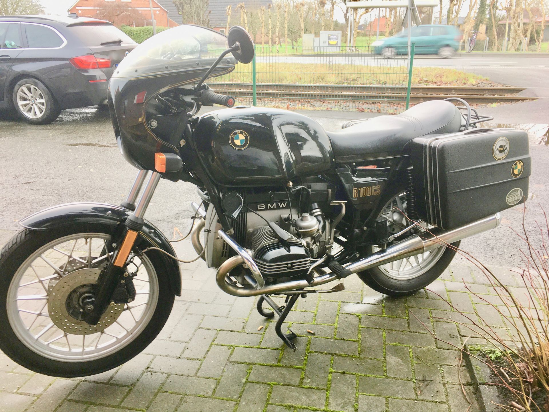 Ein schwarzes BMW-Motorrad ist auf einem gemauerten Bürgersteig geparkt