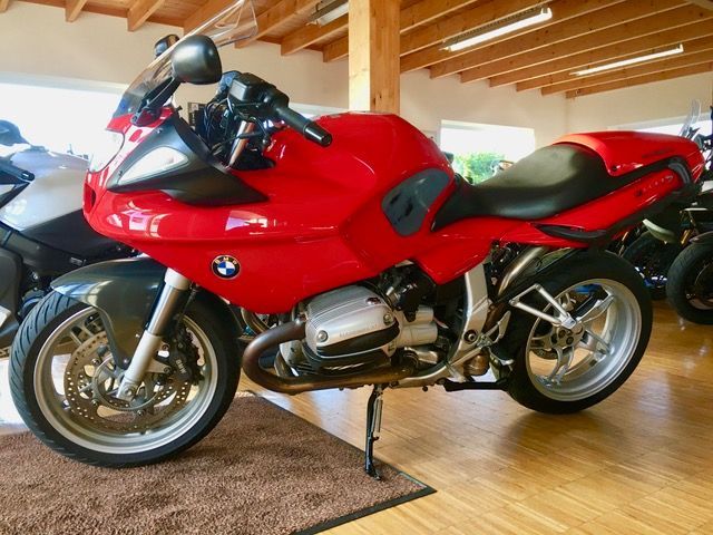 Ein rotes BMW-Motorrad steht in einem Ausstellungsraum