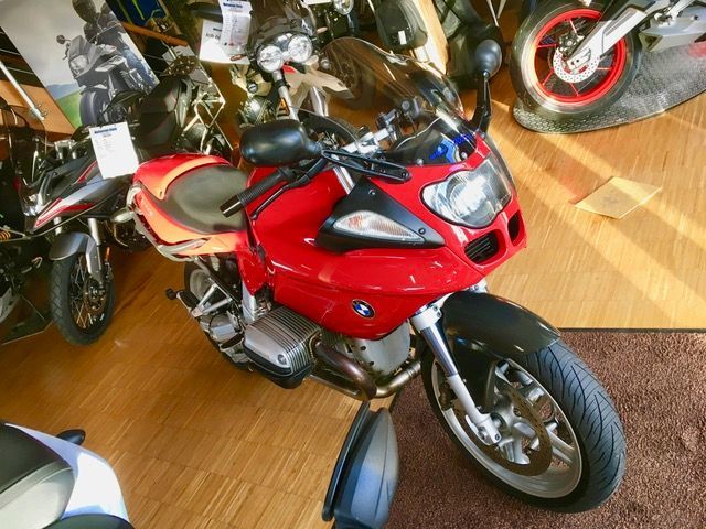 Ein rotes BMW-Motorrad steht in einem Ausstellungsraum