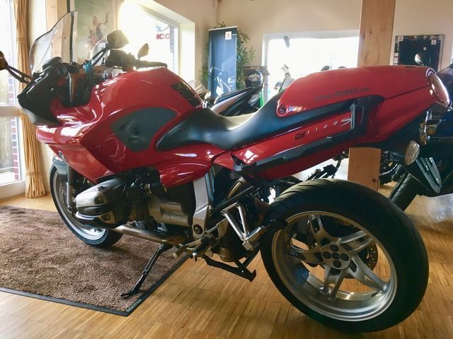 Ein rotes Motorrad ist in einem Raum geparkt