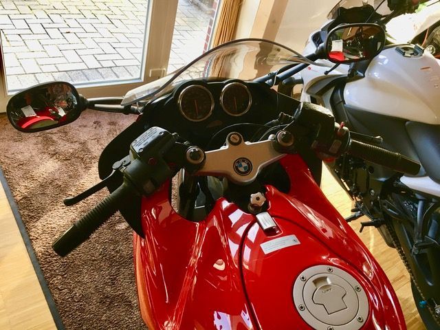 Ein rotes Motorrad ist neben einem weißen Motorrad geparkt