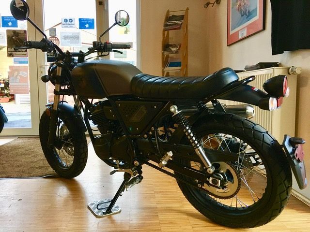 Ein schwarzes Motorrad ist in einem Wohnzimmer geparkt