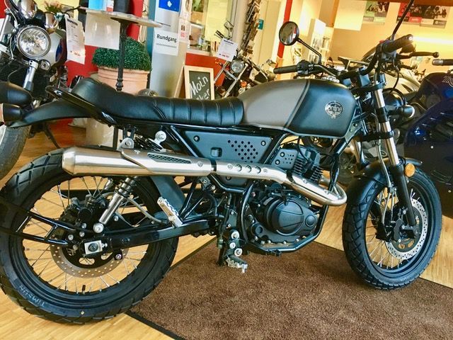 Ein schwarzes Motorrad steht in einem Ausstellungsraum