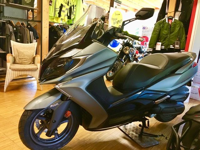 In einem Geschäft steht ein Motorroller auf dem Holzboden.