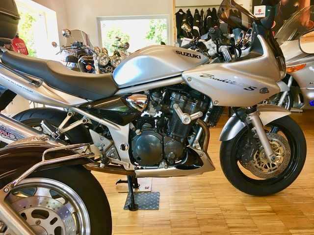 Ein silbernes Suzuki-Motorrad steht in einem Ausstellungsraum