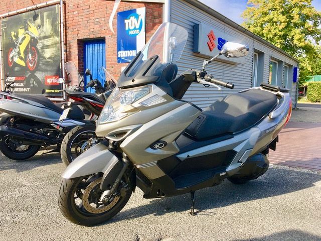 Ein Roller steht vor einem Gebäude mit der Aufschrift TÜV