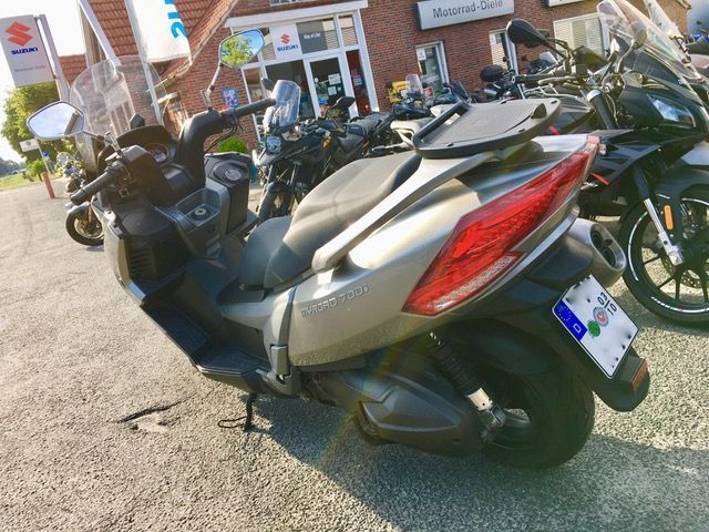 Ein Roller steht vor einem Suzuki-Laden