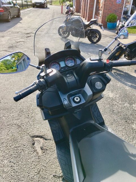 Ein Motorrad mit Windschutzscheibe ist am Straßenrand geparkt.