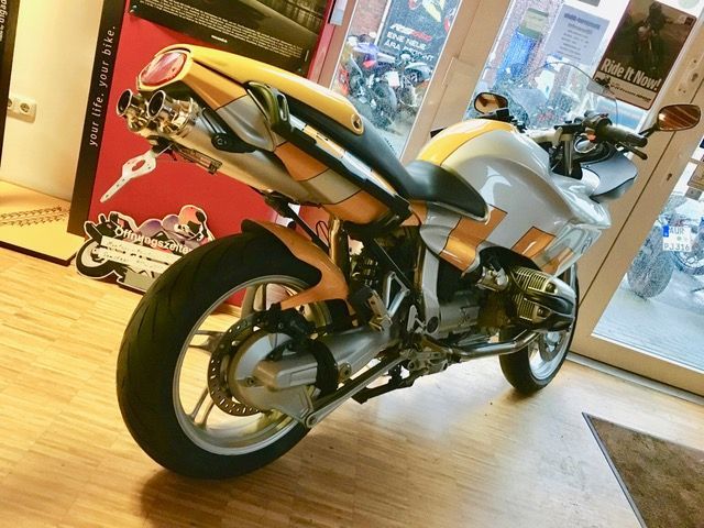 Ein Motorrad ist vor einer Glastür geparkt